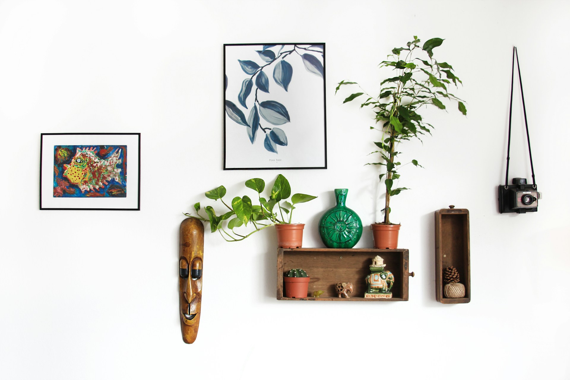 Wall displaying various picture frames and art decor securely hung using 3M Command strips for easy installation.