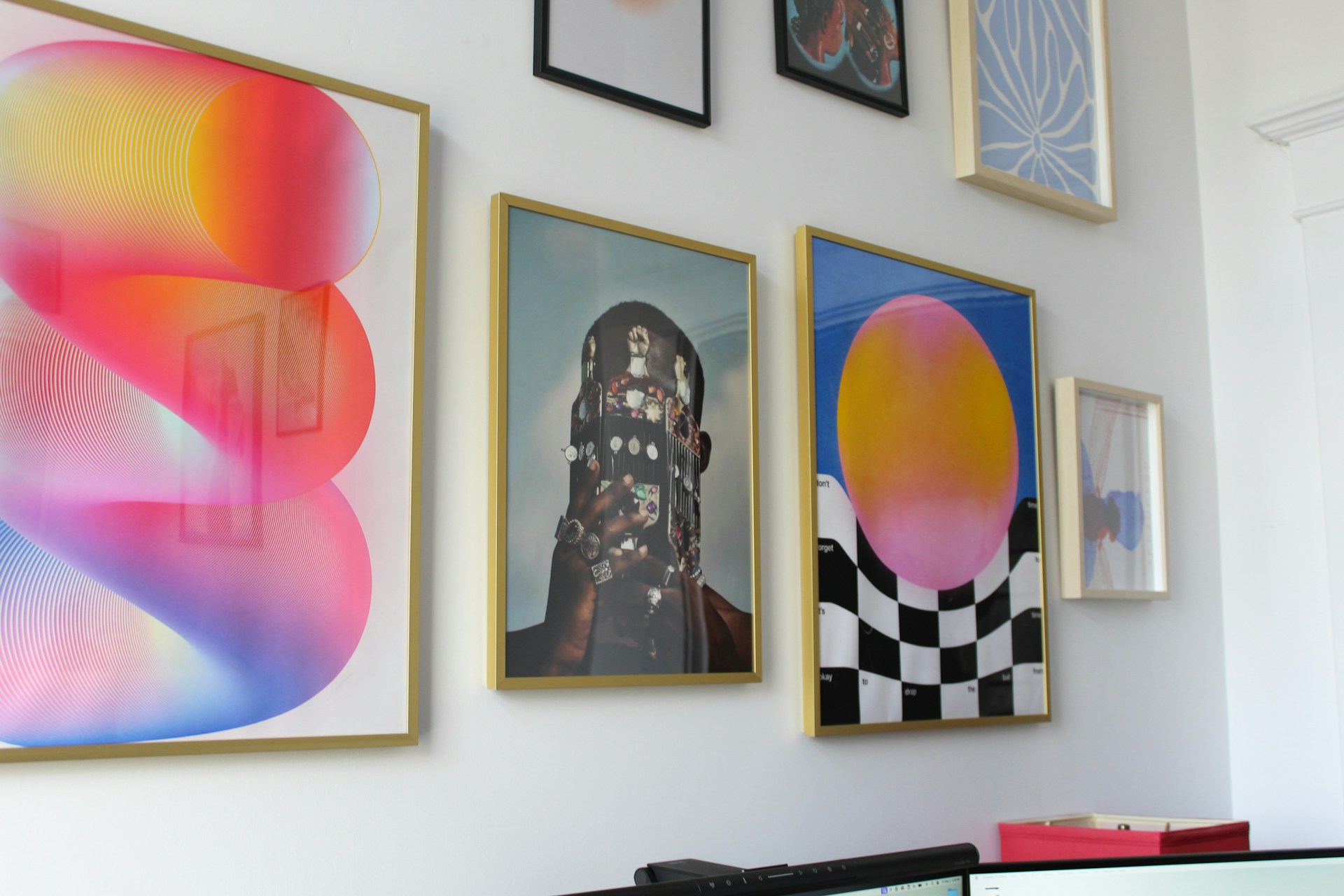 Collage of colorful wall art arranged creatively, secured with 3M Command strips for easy hanging and removal.